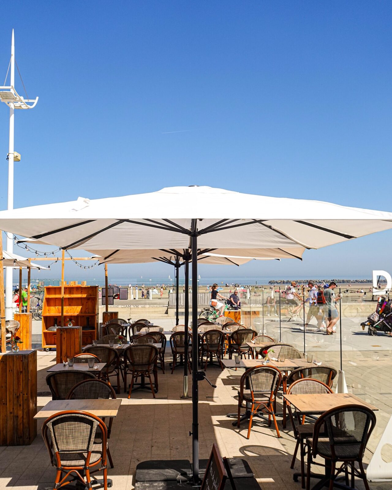 Terrasse du restaurant My Malo sous un grand parasol, face à la plage de Malo-les-Bains
