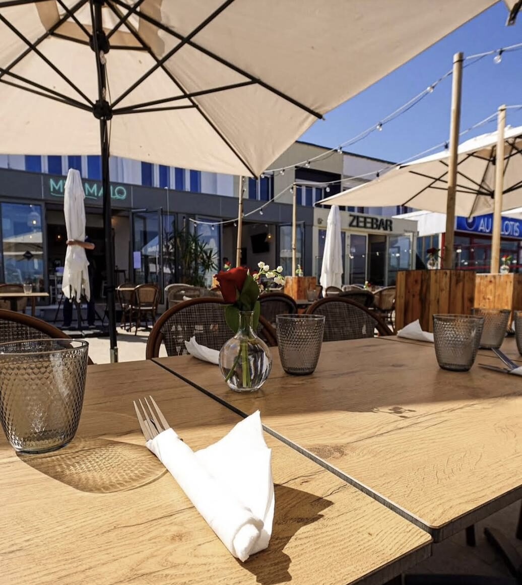 Terrasse du My Malo sous les parasols avec vue sur la mer du Nord